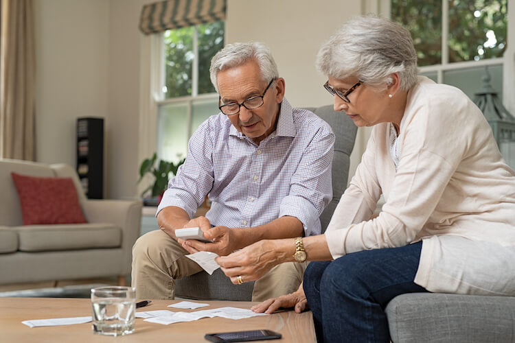 Senior couple discussing ways to save money for retirement.