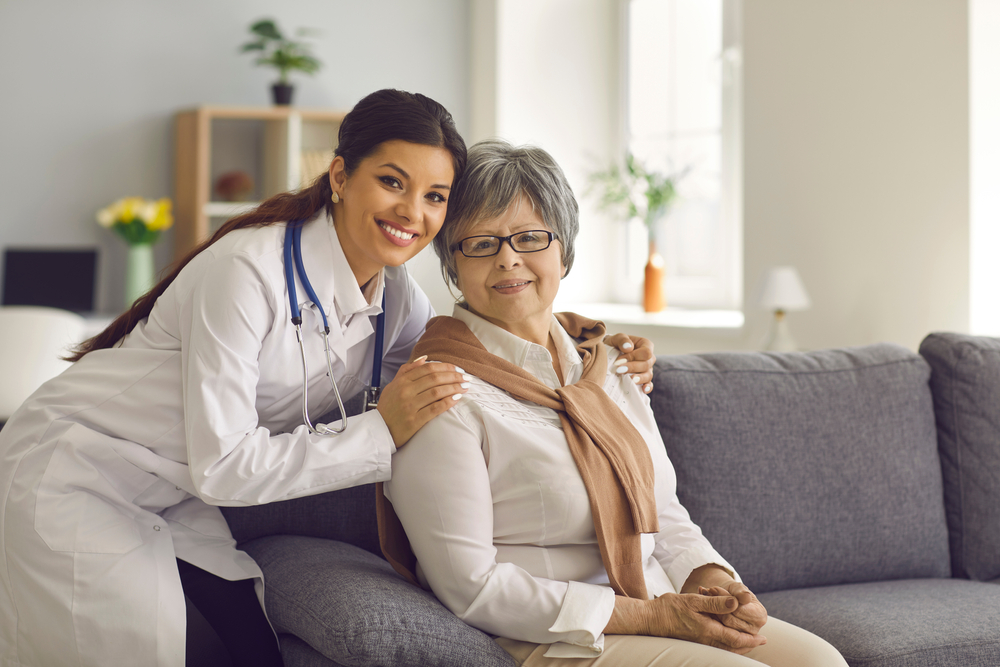 A doctor poses for a photo with a senior woman