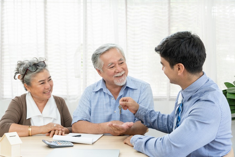 Happy senior couple receiving keys from their agent