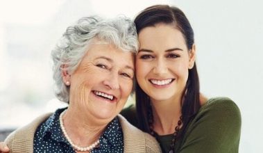 Resident and adult daughter smiling at camera
